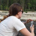 Photo of DPhil student Cathy Baldwin holding a syringe sampling at Trout River, June 2025 
