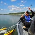 Collecting gas fluxes holding a floating chamber in place on the Mackenzie River, Fort Simpson, June 2025