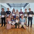 Group photo of academic award winners at their presentation, each holding their certificate