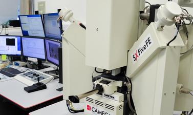 Computer system for the CAMECA SX-5 FE is shown on a table in the E-Beam Suite in the Earth Sciences Department. Control panels are also on the table. 