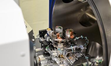 Test samples of coral and rocks in resin are loaded onto analysis tray with copper tape. The door is open to the Thermo Scientific Apreo 2 SEM in the Materials Department.