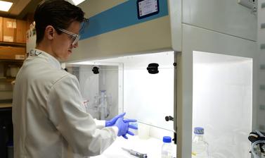 Researcher working at a fume cupboard