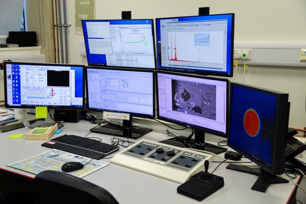 Computer system for the CAMECA SX-5 FE is shown on a table in the E-Beam Suite in the Earth Sciences Department. Control panels are also on the table. 