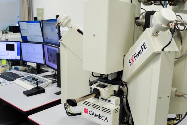 Computer system for the CAMECA SX-5 FE is shown on a table in the E-Beam Suite in the Earth Sciences Department. Control panels are also on the table. 