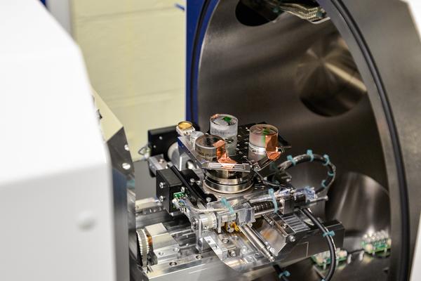 Test samples of coral and rocks in resin are loaded onto analysis tray with copper tape. The door is open to the Thermo Scientific Apreo 2 SEM in the Materials Department.