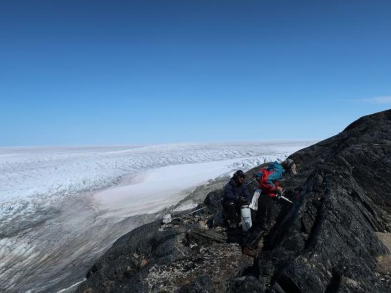 Photograph of lead author, Claire Nichols, collecting samples for paleomagnetic analysis above the Greenland Ice Sheet