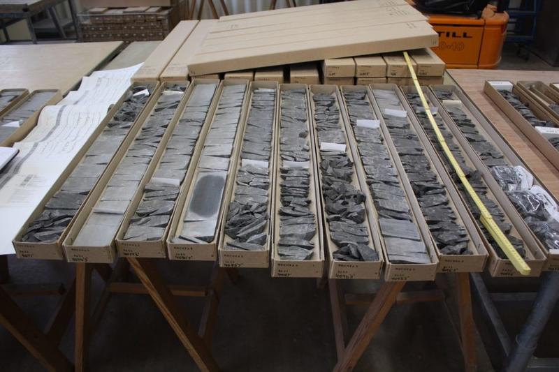 Core rock samples sit in long cardboard boxes on a table