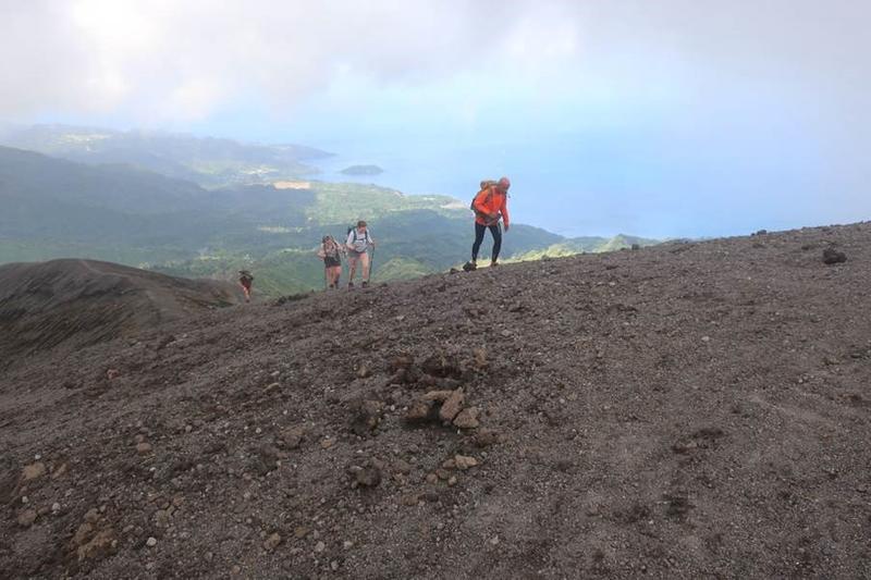 Photograph of scientists walking up the side of a volcano