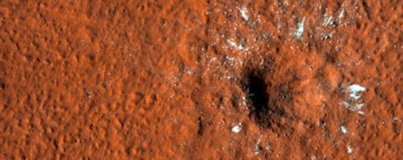 A close up image of an impact crater on the surface of Mars