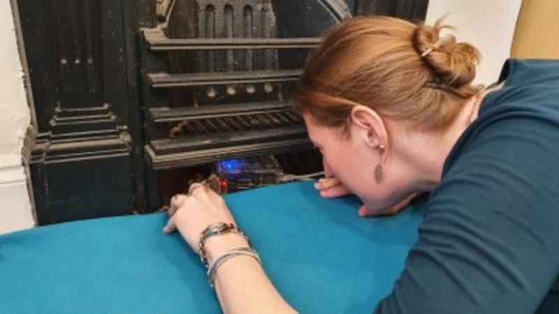 Paula looking at a seismometer