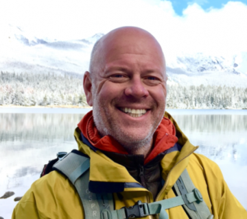 Photograph of John-Michael Kendall in front of a lake in winter
