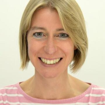 Headshot of Ros Rickaby. She is smiling and wearing a pink and white striped jumper.