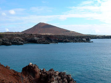 Ascension Island (credit: Flickr) Photograph of Ascension Island, with dark brown volcanic hills and blue surrounding ocean