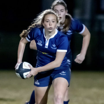 Stella Rugby Action shot of Stella Farmer playing rugby, about to pass the ball