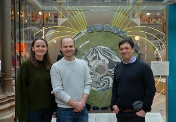 Lunar magnetic field team in front of a museum display case showing Earth's magnetic field