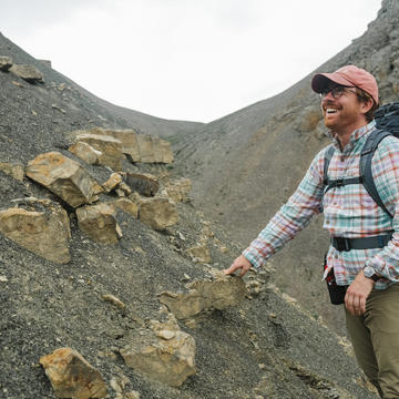 Ross Anderson during fieldwork, looking at some rocks