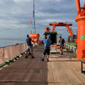 Ocean bottom seismometers being deployed from a ship