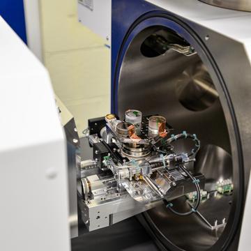 Test samples of coral and rocks in resin are loaded onto analysis tray with copper tape. The door is open to the Thermo Scientific Apreo 2 SEM in the Materials Department.