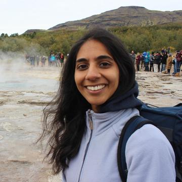 Photo of Kamini Manick standing in front of a geyser in Iceland