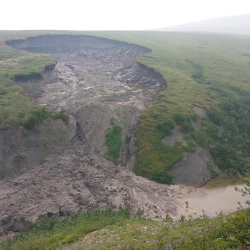 Thaw Slump on the Peel Plateau Thaw slump on the Peel Plateau, which exposes sulfide and carbonate minerals in glacial sediments to surface weathering reactions in lower slope regions with relict ice (Credit: Suzanne Tank)